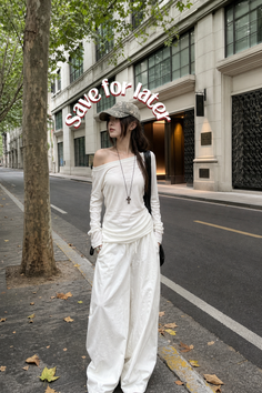 Woman in an off-shoulder top and wide-leg pants on a city street