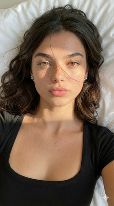 Woman with freckles and brown hair lying down with soft lighting on her face