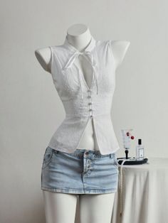 Mannequin wearing a white sleeveless top and a denim mini skirt