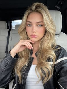 Woman with blonde hair and a leather jacket in a car interior