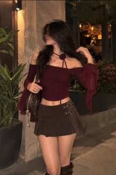 Woman in an off-shoulder top and mini skirt outdoors at night