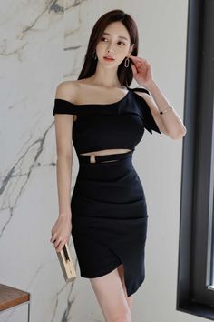Woman in a black off-shoulder dress with cut-outs and a high slit