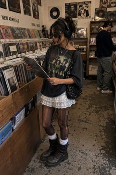 Woman in a record store wearing headphones and a graphic t-shirt