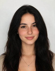 Young woman with long dark hair and a subtle smile wearing a necklace