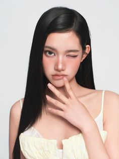 Woman with long black hair, winking and touching her lips