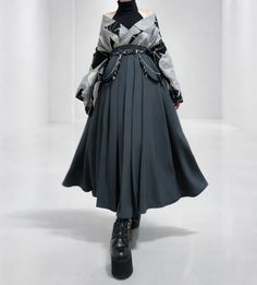 Person in dark clothing with a pleated skirt and platform boots
