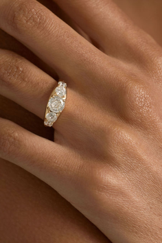 Close up of a hand wearing a gold ring with multiple diamonds