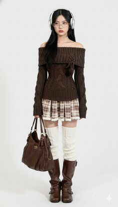 Woman in an off-shoulder brown sweater and plaid skirt with headphones and boots