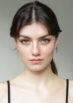 Woman with dark hair and green eyes in a portrait shot with soft lighting