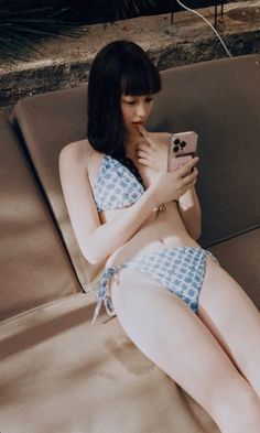 Woman in a blue and white bikini lying on a lounge chair outdoors