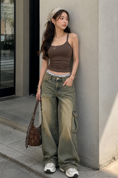 Woman in a brown tank top and baggy jeans with a bandana on her head