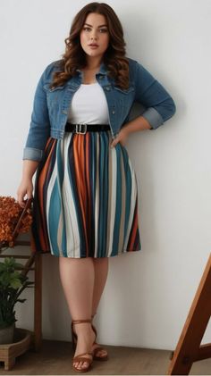 Woman with long brown hair wearing a denim jacket and striped skirt