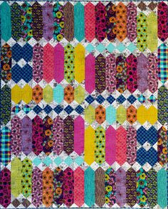 A colorful quilt with a geometric pattern made from various patterned fabrics