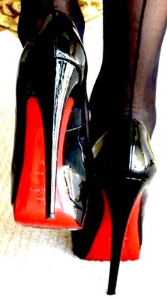Woman wearing black high heels with red soles and black stockings