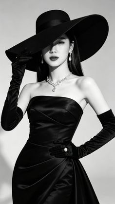 Woman in a wide-brim hat, long gloves, and a strapless dress with diamond jewelry