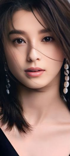Close up portrait of a woman with long dark hair and earrings