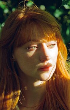 Woman with red hair and green eyes in soft golden hour light