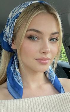 Blonde woman with a blue patterned scarf and an off-shoulder top