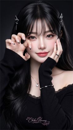 Woman with long black hair wearing a black top and jewelry, making a playful gesture