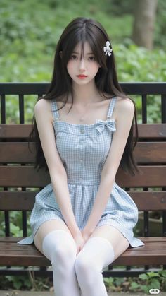 Woman with long dark hair wearing a gingham dress and white thigh highs, sitting outdoors