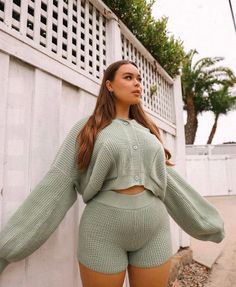 Woman in a light green knitted top and shorts outdoors
