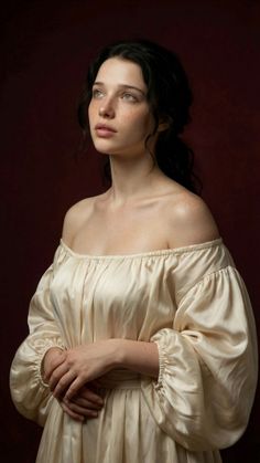 Woman with dark hair and freckles wearing an off-shoulder dress