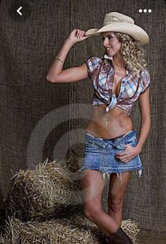 Woman in a cowboy hat, plaid shirt, and denim skirt posing in a studio