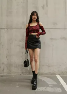 Woman in a red patterned crop top and black mini skirt with platform boots
