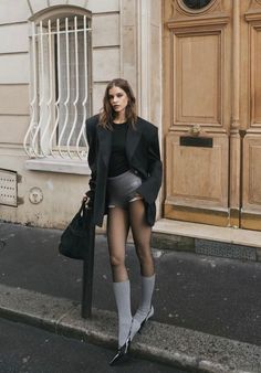 Woman in an oversized blazer and short shorts standing on a street