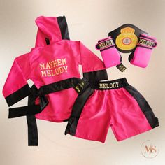 Pink and black boxing outfit with gold lettering, including robe, shorts, gloves, and belt