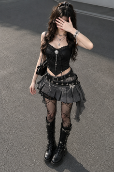 Woman in gothic-style clothing with a black corset top and pleated skirt outdoors