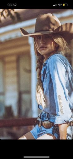 Woman in a cowboy hat, denim shirt, and shorts with braided blonde hair