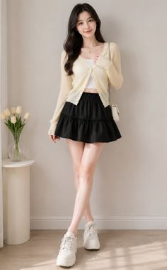 Woman with long black hair wearing a cardigan and mini skirt indoors