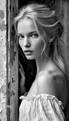Blonde woman with an off-shoulder top leaning against a wall with peeling paint