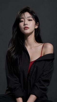 Woman with long black hair wearing a red camisole and black shirt