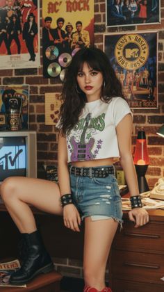 Woman in a crop top and denim shorts with a rock and roll aesthetic in an indoor setting