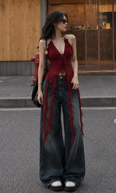 Woman in a red halter top and wide leg jeans on a street