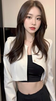 Woman with long brown hair wearing a white jacket and black crop top