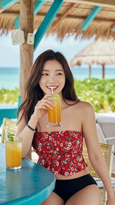 Woman in a floral top and bikini bottom drinking a beverage at a beachside bar