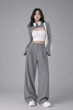 Woman in a white tube top, gray bolero, and wide leg pants with headphones