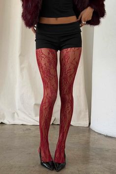 Person in red lace tights, black shorts, and a cropped top with a fur jacket
