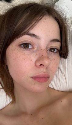 Woman with freckles and brown hair looking directly at the camera