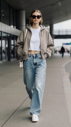 Woman in a hoodie, crop top, and baggy jeans walking outdoors