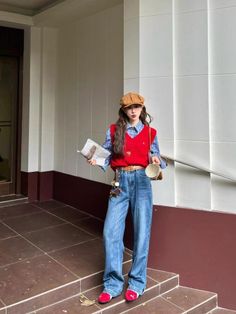 Woman in a plaid shirt, red vest, and wide leg jeans holding a newspaper