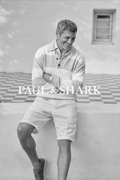 Man in a striped sweater and white shorts smiling outdoors