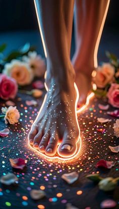 Feet with glowing outlines and glitter surrounded by rose petals