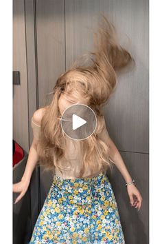 Woman with long blonde hair in motion, wearing a floral skirt and off-shoulder top