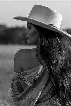 Woman in a cowboy hat and denim jacket with exposed shoulder in black and white