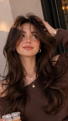 Woman with long brown hair and an off-shoulder top in soft golden hour light