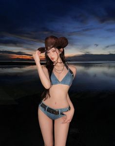 Woman in a denim bikini and cowboy hat on a beach at sunset